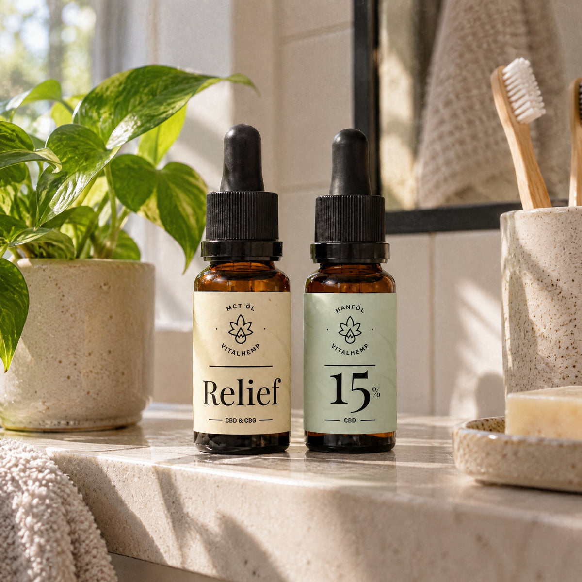 VITALHemp Relief und CBD-Oel 15 Prozent Flaschen zusammen auf dem Badregal neben einer Pflanze