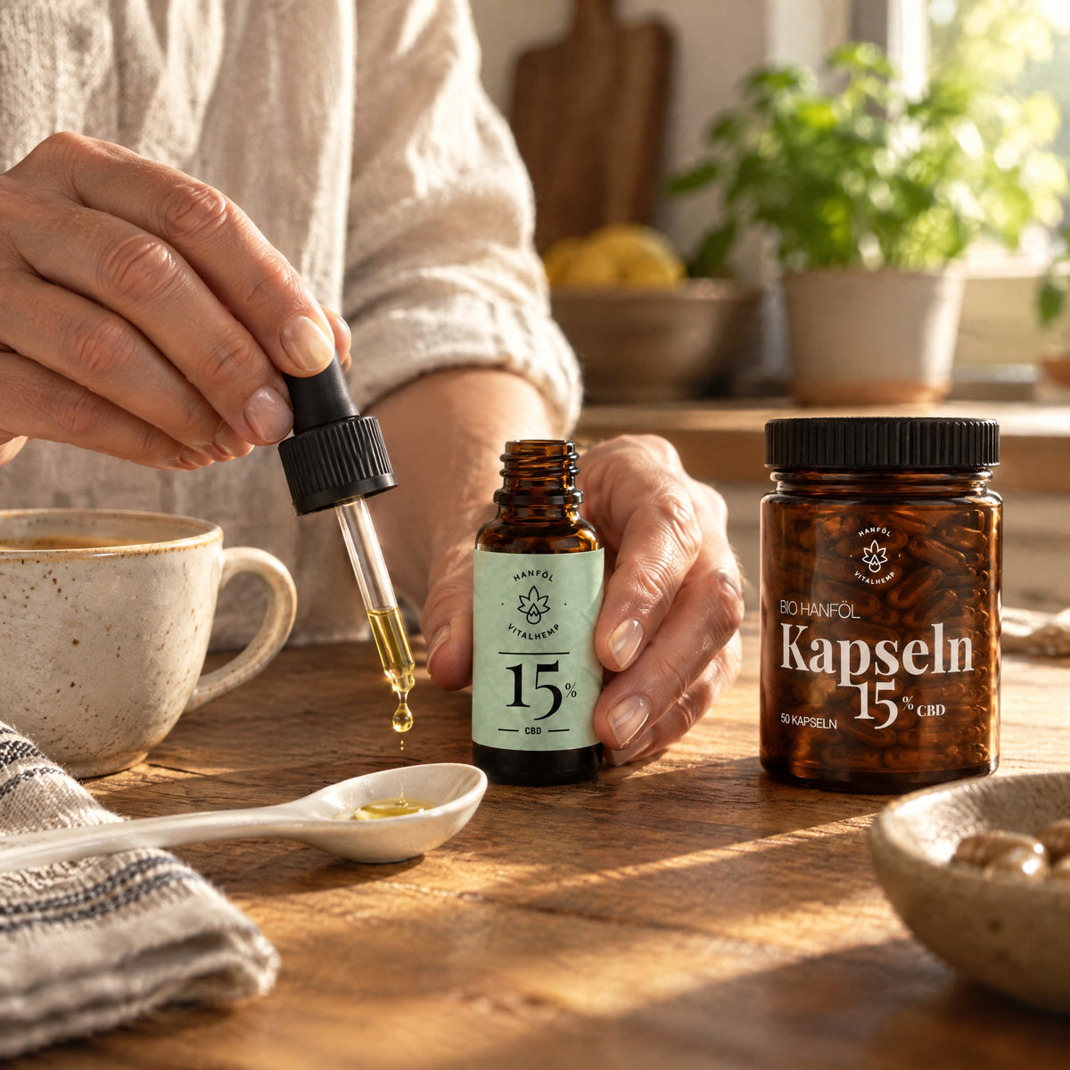 Hände geben einen Tropfen CBD-Öl 15 % auf einen Keramiklöffel in der Küche, daneben die Kapsel-Dose