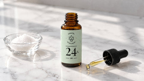 Flasche VITALHemp Pure 24 % CBD-Öl auf hellem Marmor, minimalistische Aufnahme für das Thema Reinheit.