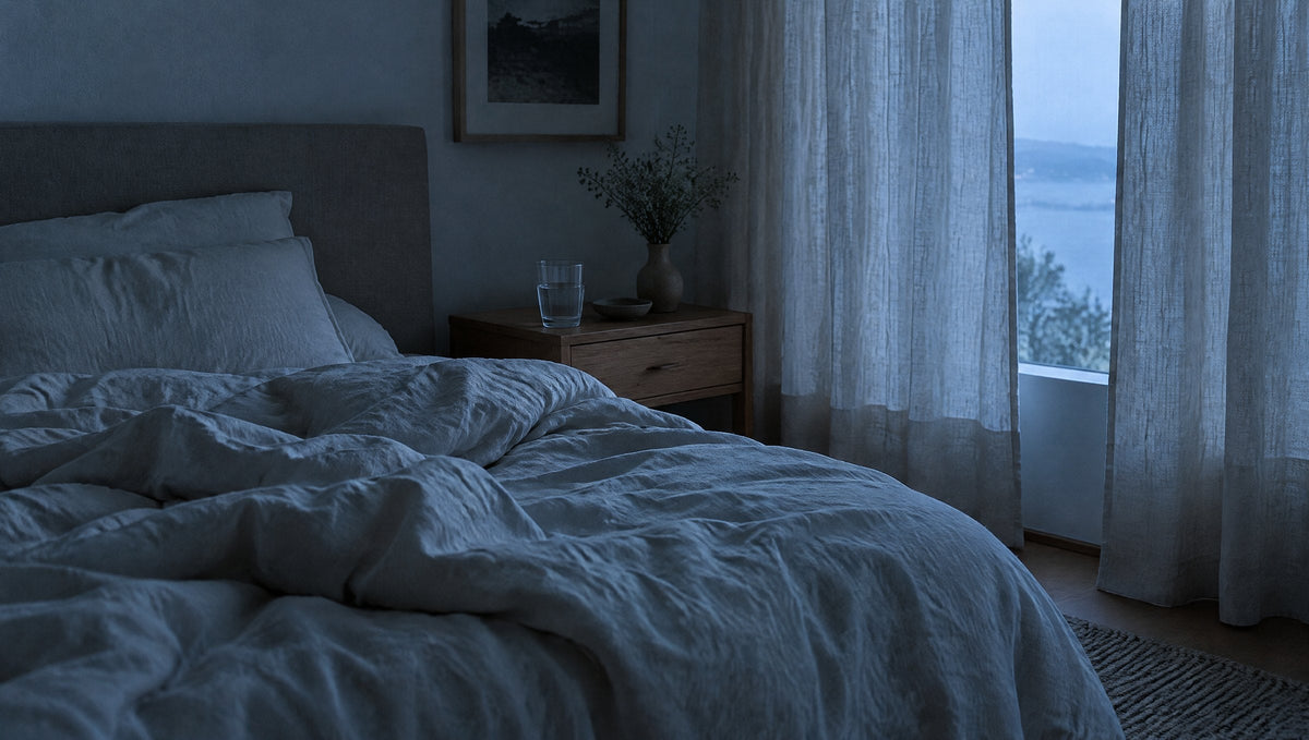 Schlafzimmer in der Morgendämmerung mit zerwühlter Leinenbettwäsche
