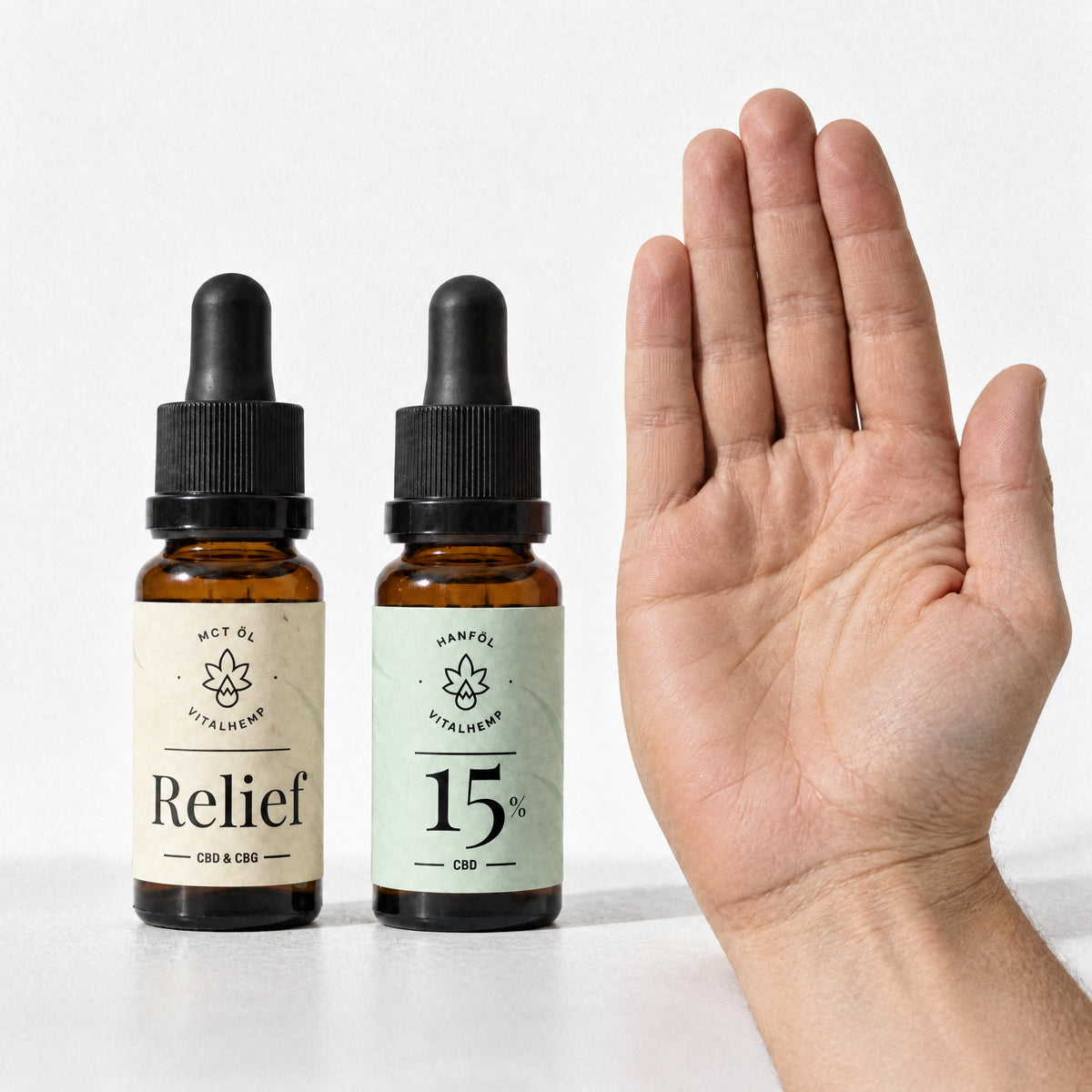 VITALHemp Relief und CBD-Oel 15 Prozent Flaschen neben einer Hand zum Groessenvergleich