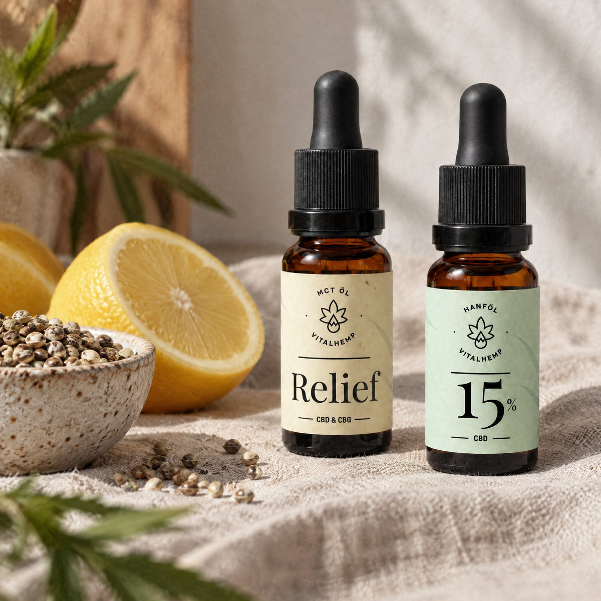 VITALHemp Relief und CBD-Oel 15 Prozent Flaschen neben einer Zitrone und einer Schale Hanfsamen