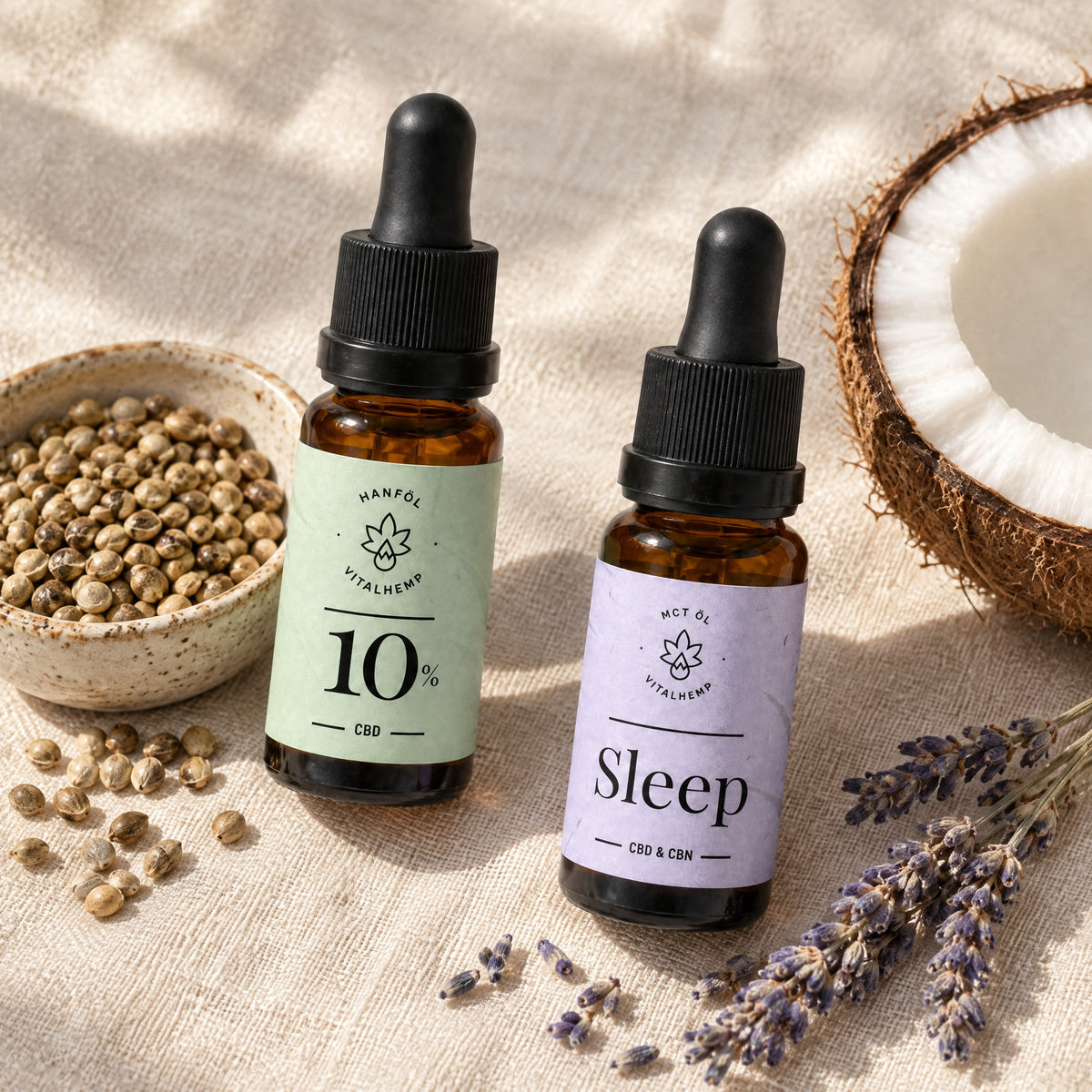 CBD-Öl 10 % und Sleep-Öl auf Leinen, daneben Hanfsamen, Lavendelzweige und eine halbe Kokosnuss