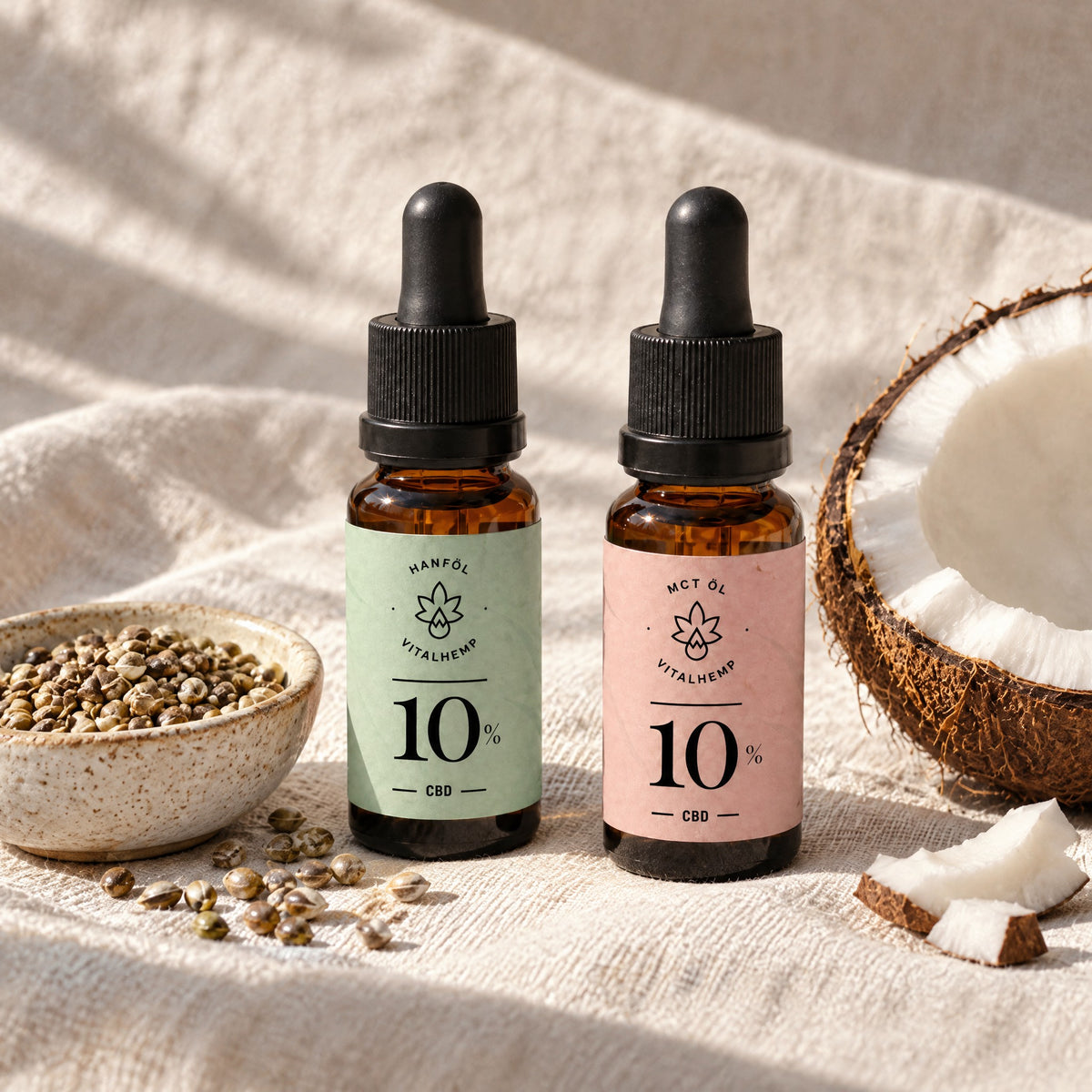 CBD-Öl 10 % in Bio-Hanföl neben Hanfsamen und CBD-Öl 10 % in Bio-MCT-Öl neben einer halben Kokosnuss