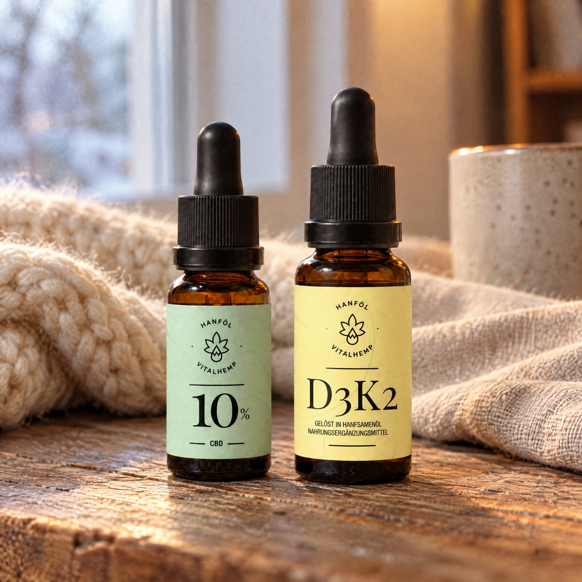 Winter-Set: CBD-Öl 10 % mit mintgrünem und Vitamin D3+K2 mit gelbem Etikett auf Eichenholz mit Strickdecke