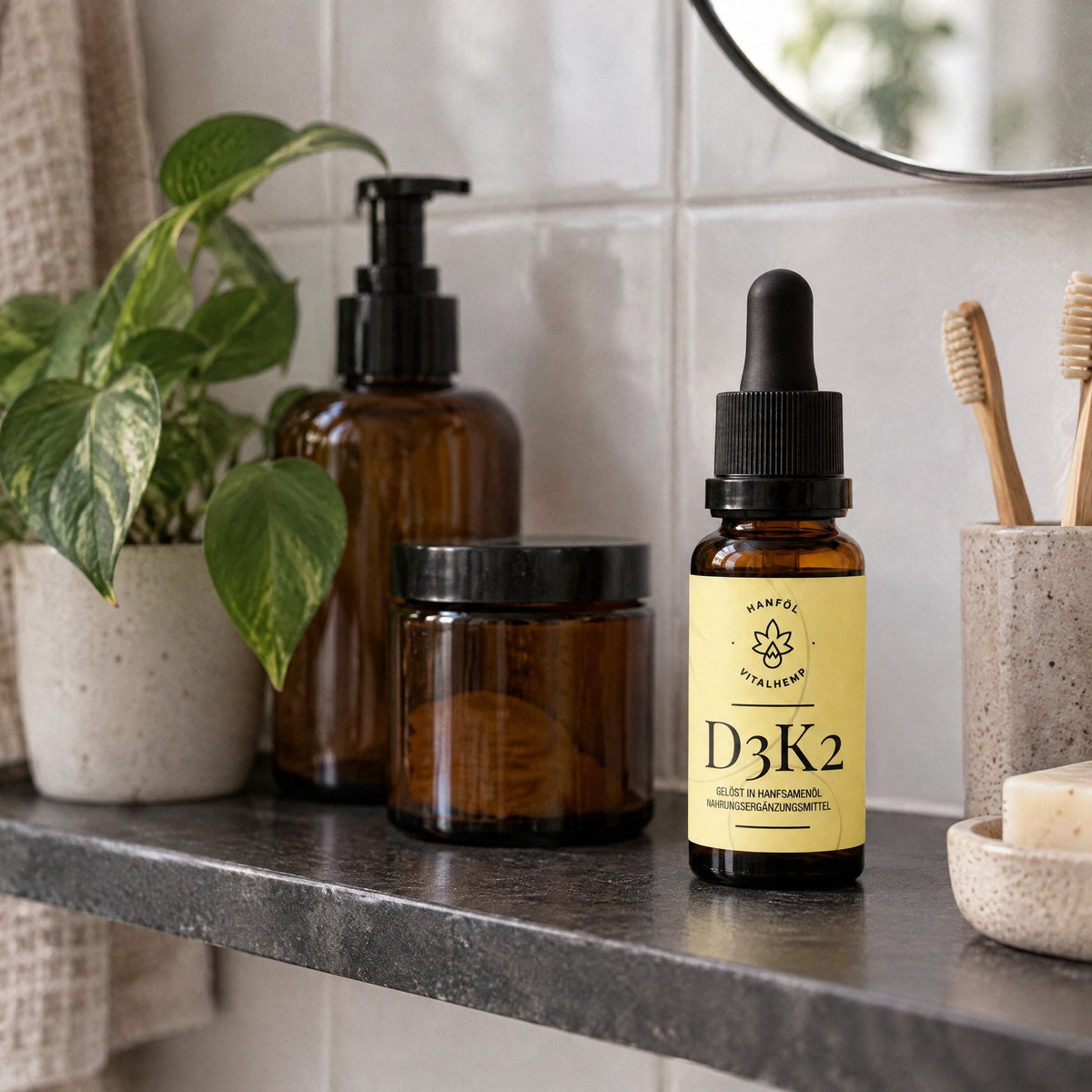 VITALHemp Vitamin D3+K2 Flasche im Badregal zwischen Pflanze und Glastiegeln